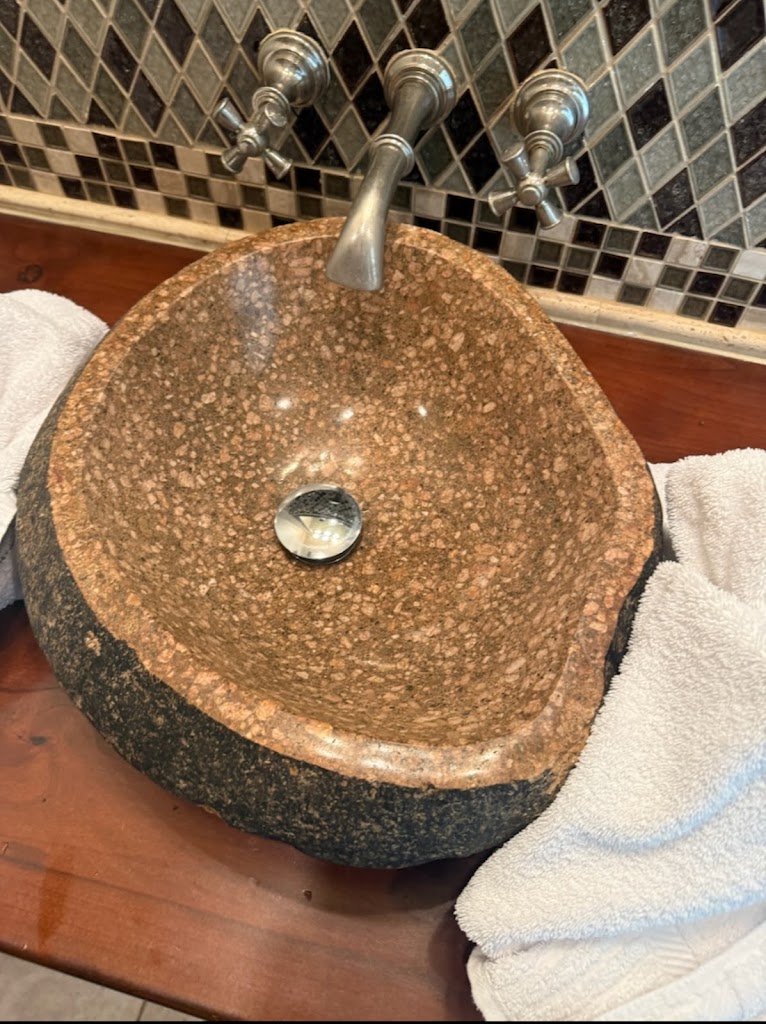 Stone vessel sink installation with matching tile backsplash